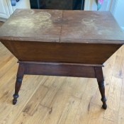 A vintage wooden table with storage underneath.