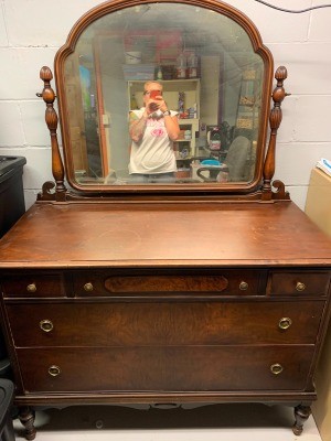 A vintage dresser with mirror.