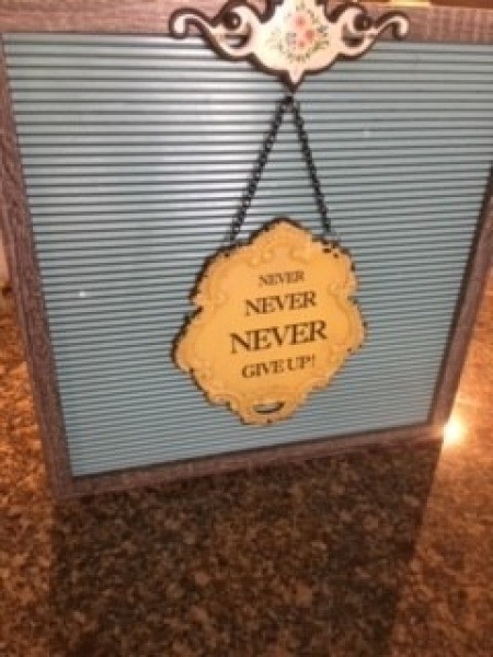 Hanging a sign on the board that says "Never never never give up!"