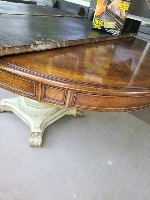 A wooden dining table with a white colored base.