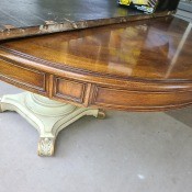 A wooden dining table with a white colored base.