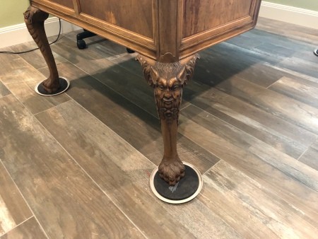 The carved legs of an antique wooden desk.