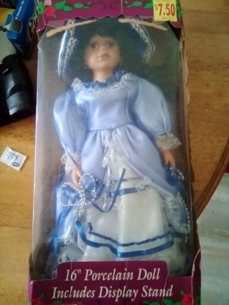 A collectible porcelain doll in a box.
