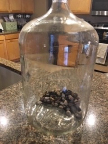 Gravel placed inside a five gallon jug.