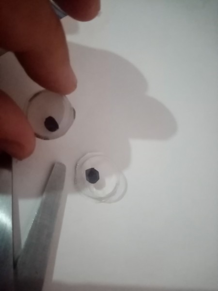 Cutting holes to fit the wiggly eyes.