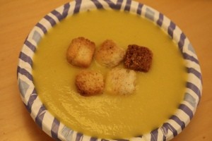 A bowl of zucchini soup with croutons.