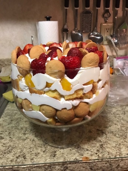 A fruit and cream trifle in a clear bowl.