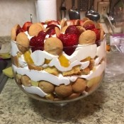 A fruit and cream trifle in a clear bowl.