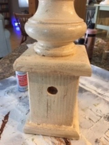 Applying a coat of crackle paint on the birdhouse.