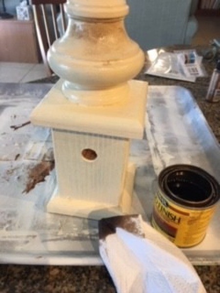 Aging the birdhouse using stain.