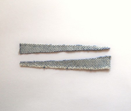 Two diagonal pieces cut from a strip of material.