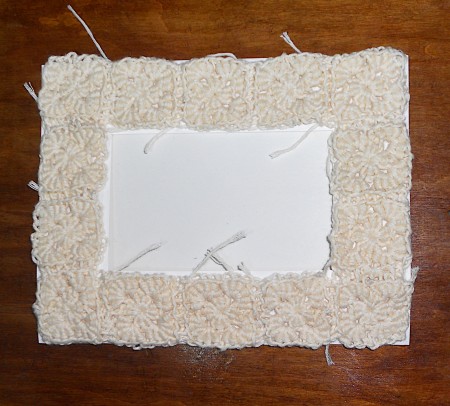 A frame made from crocheted squares.