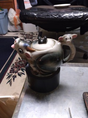 A whimsical teapot in a cow theme.