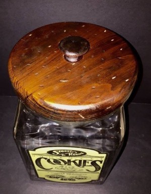 An old fashioned cookie jar with a wooden lid.