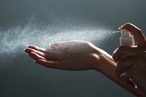 Using a spray bottle to sanitize hands.