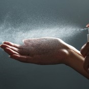 Using a spray bottle to sanitize hands.