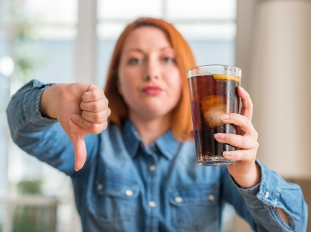 A disapproving woman with a glass of soda