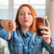 A disapproving woman with a glass of soda