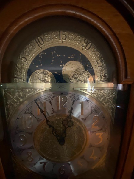 A close up of the face of a grandfather clock.