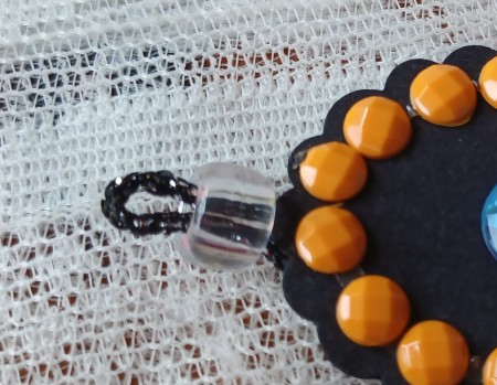 Adding a bead to the pendant loop.