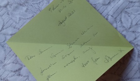 Opening up the folded letter.