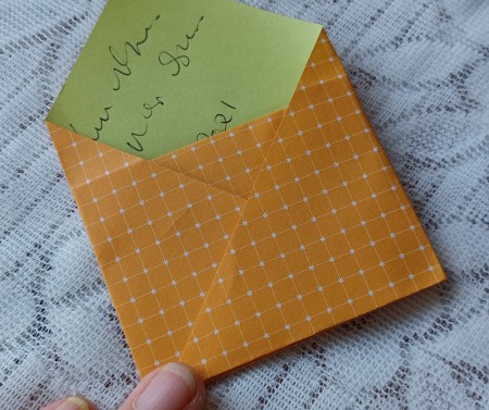 Folding the letter into an envelope shape.