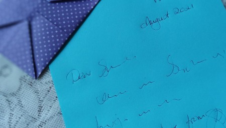 A handwritten letter next to the envelope.