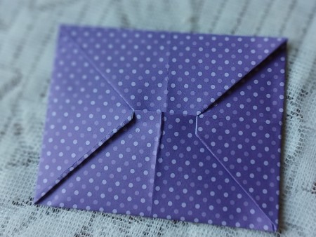 Tucking the corner into the envelope.