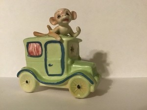 A monkey in a old fashioned car.