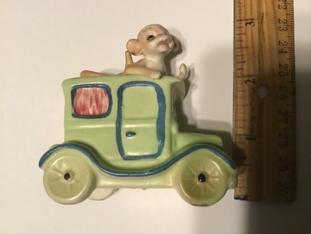 A monkey in a old fashioned car.