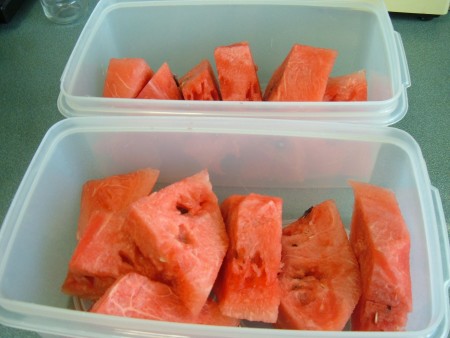Two containers full of watermelon slices.
