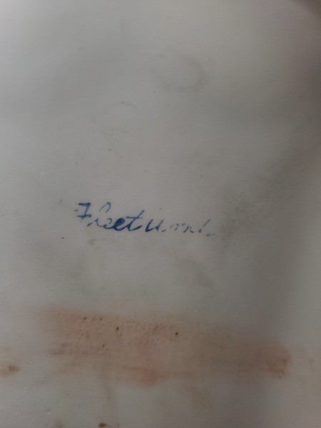 A signature on the bottom of a figurine.