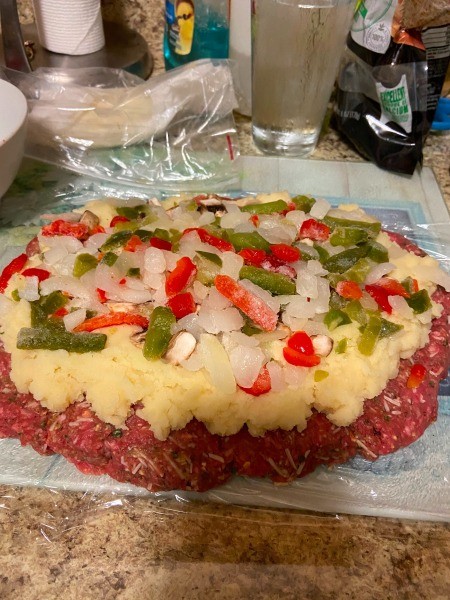 Adding peppers and onions to the meatloaf.