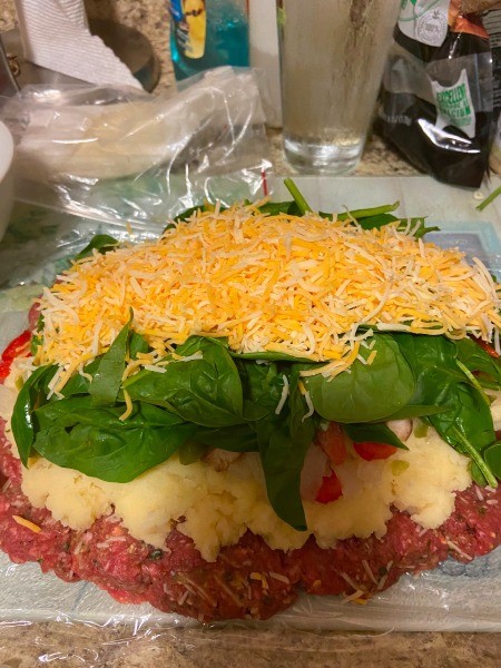 Adding the cheese to the top of the meatloaf.