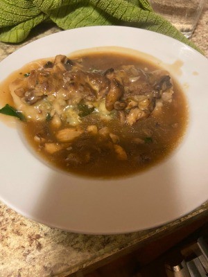 A plate of stuffed meatloaf covered in mushroom gravy.