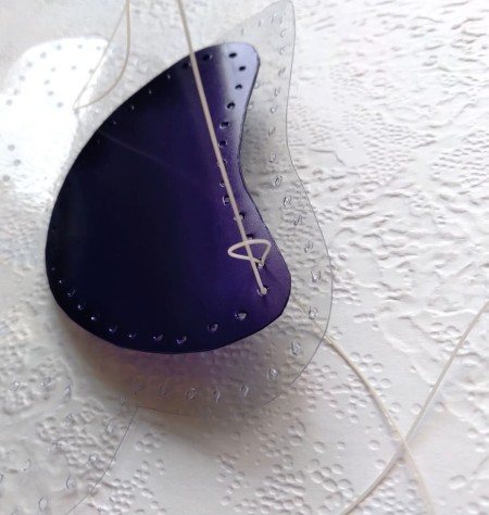 Sewing the paw print to the clear plastic.