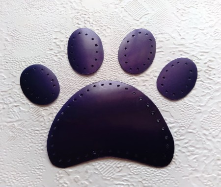 The paw prints with holes punched in.