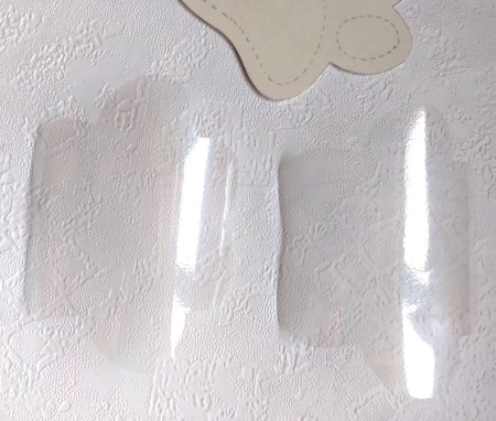 Cutting out the clear paw shapes.