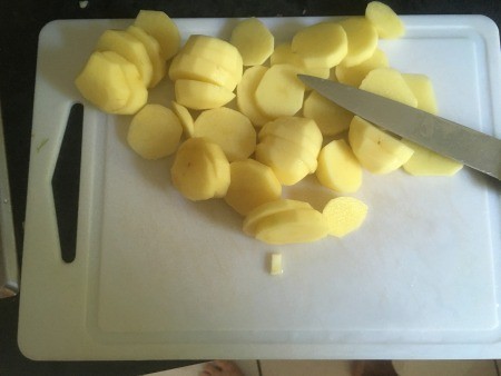 Cutting a potato into slices.