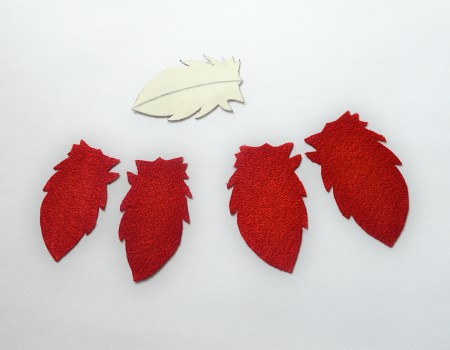 Two pairs of mirrored feathers cut from velvet.