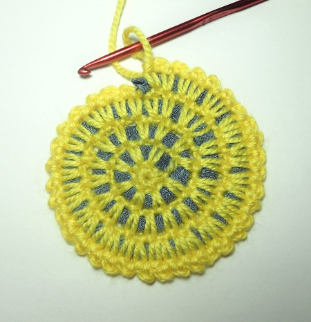 Completing the crocheted coaster.