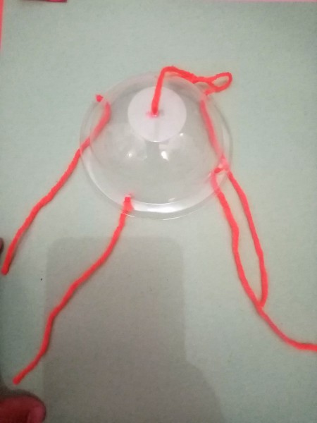 Yarn through four holes on the sides and one on the top.