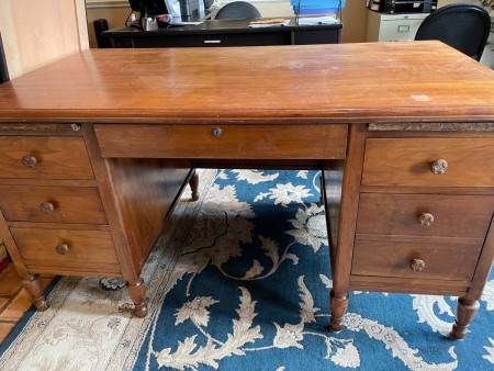 A wooden desk with drawers.