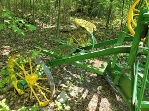 An old fashioned green and yellow grader.