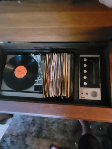 A console stereo system with records inside.