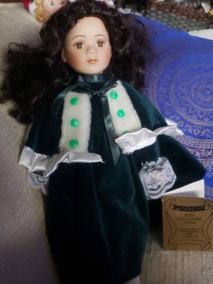 A doll wearing a green velvet dress.