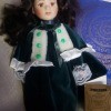 A doll wearing a green velvet dress.