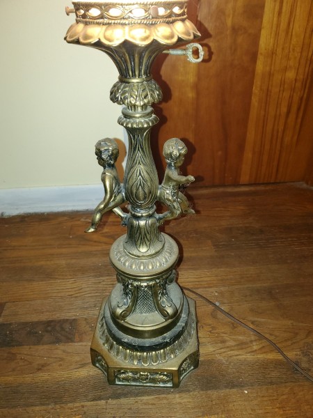 Brass cherubs on the base of a lamp.