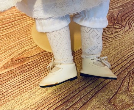 Shoes on a porcelain doll's feet.