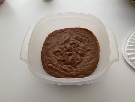 Placing the pudding in a tupperware container.